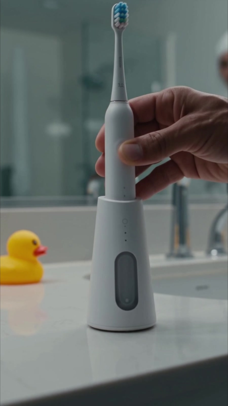 White electric toothbrush in its charging base